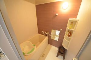 ein kleines Bad mit einer Badewanne und einem Waschbecken in der Unterkunft River Side Namba 200 in Osaka + 23 Fotos