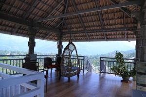 een kamer met een tafel en stoelen op een balkon bij Room in Villa - Luxury cottages with beautiful mountain view in Anachal