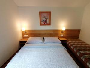 a small bedroom with two beds and two lamps at Penzion Biely Potok in Terchová