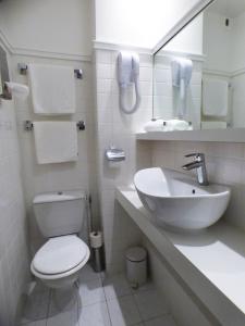 a bathroom with a toilet and a sink and a mirror at Terminus du Forez Saint-Etienne Centre Gare Chateaucreux in Saint-Étienne