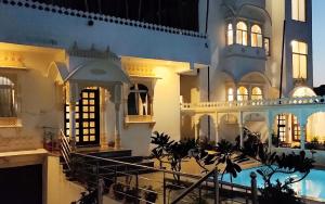 a large building with a swimming pool in front of it at Royal Heritage Haveli Udaipur in Udaipur