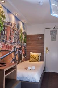 1 dormitorio con 1 cama con una pintura en la pared en The Townhouse Hotel, en Ámsterdam