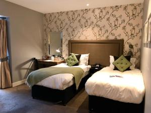 a hotel room with a bed, chair, and nightstand at The Alma Hotel in London