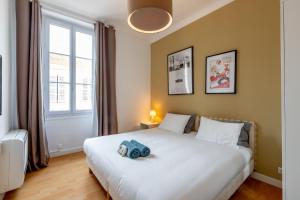 un dormitorio con una cama con un animal de peluche en Central location 3 bedrooms - 1mn Croisette - 5mn Palais en Cannes