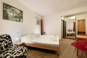 a bedroom with a bed and a chair and a mirror at Hotel U Kabinky in Janske Lazne