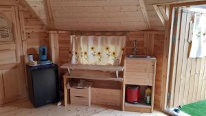 uma pequena cozinha num chalé de madeira com um lavatório em Chalet Finlandais et Sauna 2 pers em Gosnay