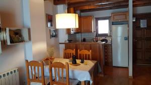普拉德勒米塔的住宿－Un rincón especial en VALL DE BOI，厨房配有桌椅和白色冰箱。