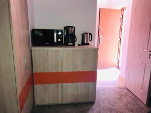a wooden cabinet with a microwave on top of it at Orange House Constanta in Constanţa
