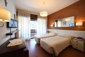 um quarto de hotel com duas camas e um espelho em Hotel Corona em Val di Zoldo