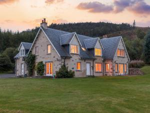 una casa grande en un campo de hierba en Rowan House, en Inveran