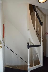 a stairway with white rails and a white stair case at The Townhouse Hotel in Amsterdam