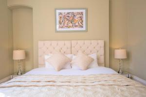 ein Schlafzimmer mit einem großen weißen Bett mit zwei Lampen in der Unterkunft Elizabeth House 1 - By Luxury Apartments in Cheltenham
