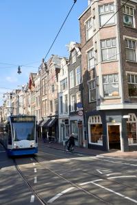 Un autobús azul y blanco conduciendo por una calle de la ciudad en The Townhouse Hotel, en Ámsterdam
