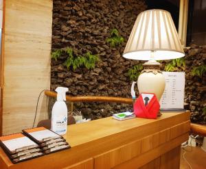Pearl Hotel Jeju في جيجو: طاولة عليها مصباح وزجاجة