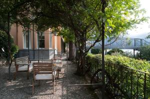 a group of benches sitting next to a fence at Villa Nina Relais Boutique B&B in Carate Urio +14 photos