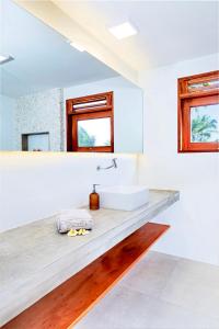 Baño blanco con lavabo y espejo en Windtown Beach Hotel en Cumbuco