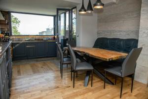 a kitchen and dining room with a wooden table and chairs at ART LUXURY Apartment in Burgas