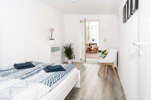 a white bedroom with two beds and a mirror at Ko-Living - Händel Suite - Altstadt mit Küche, Smart TV & Dachterrasse in Halle an der Saale