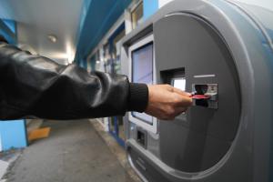 een persoon in een leren jas die geld in een machine stopt bij Kyriad Direct Poitiers - Gare du Futuroscope in Chasseneuil-du-Poitou