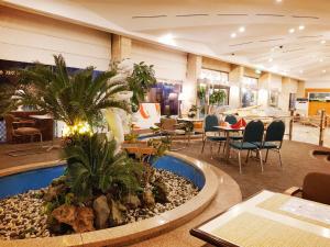 a hotel lobby with a pool and tables and chairs at Pearl Hotel Jeju in Jeju