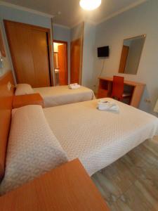 Habitación de hotel con 2 camas y escritorio en Casa Tito, en Campo Lameiro