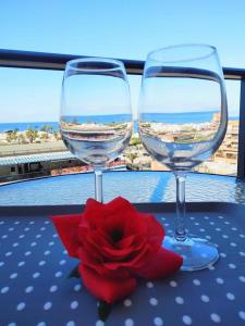 two wine glasses and a red rose on a table at Ocean View Elegant Magic Apartment in Palm-Mar