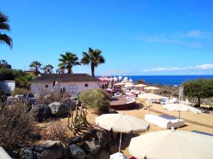a group of umbrellas and chairs on a beach at Ocean View Elegant Magic Apartment in Palm-Mar