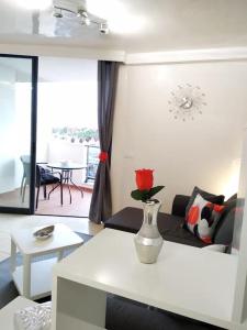 una sala de estar con un jarrón con una rosa roja en Ocean View Elegant Magic Apartment en El Palmar