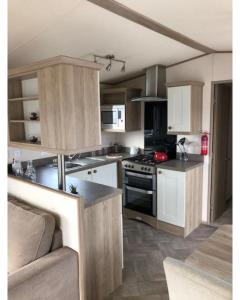 uma cozinha com armários brancos e um forno com placa de fogão em 37 Bay View Oceans Edge by Waterside Holiday Lodges em Lancaster