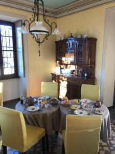 a dining room with a table and yellow chairs at Villa il Maiale Bianco B&B in San Fedele Intelvi