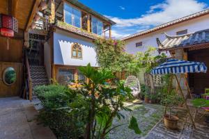 a courtyard in a house with plants and an umbrella at Dreamer Inn in Lijiang