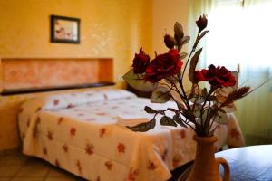 a bedroom with a bed and a vase with flowers in it at Villa Fiori Beach in Menfi