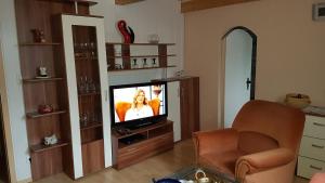 a living room with a television and a chair at Ferienwohnung Raabe in Lahr