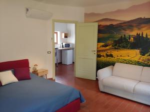 科萊薩爾韋蒂的住宿－B & B CUORE TOSCANO，一间卧室配有床、沙发和绘画