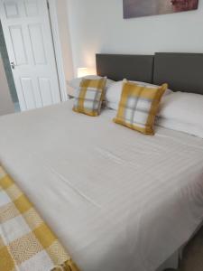 a large white bed with two pillows on it at Trevarrian Lodge in Newquay