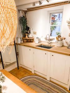 una cocina con armarios blancos y fregadero en Snowdonia Stone Cottage en Beddgelert