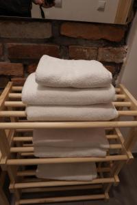 a stack of white towels on a wooden shelf at Centrum Łąkowa 1 in Wünschelburg +90 photos