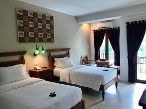 a hotel room with two beds and a window at Ao Nang Colors Hotel - Aonang Beach in Ao Nang Beach