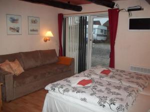 ein Wohnzimmer mit einem Sofa und einem Bett in der Unterkunft Bed and Breakfast Vester Hjermitslev in Saltum