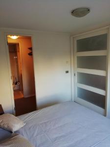 1 dormitorio con cama blanca y ventana en Bello Centro, en Concepción