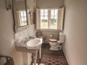 a bathroom with a sink and a toilet and a window at The Delaval Rooms in Lincoln +6 photos