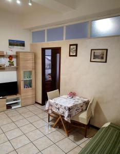 ein Wohnzimmer mit einem Tisch und einem TV in der Unterkunft Appartamento da Raffaella CIR O12133 CNI OOO39 in Varese