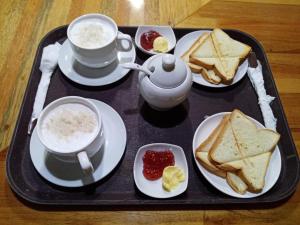 een dienblad met broodjes en een kopje koffie bij Casa Nativa Iquitos in Iquitos