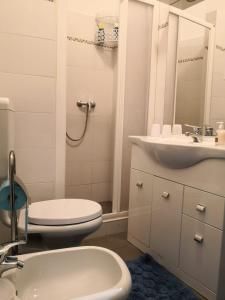 een witte badkamer met een toilet en een wastafel bij Appartamento da Raffaella CIR O12133 CNI OOO39 in Varese