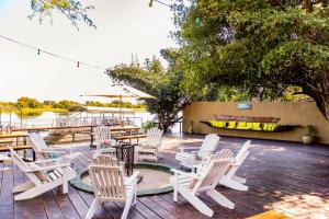 a group of white chairs and tables on a patio at Zambezi Mubala Campsite in Katima Mulilo