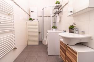 a white bathroom with a sink and a shower at Apartment Mandlgasse I contactless check-in in Vienna