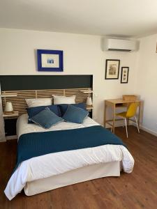a bedroom with a large bed with blue pillows at Les cèdres in Uzès