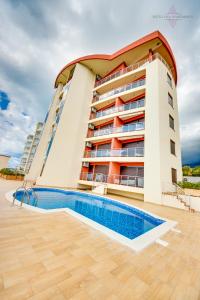 a building with a swimming pool in front of it at Sveti Luka Apartments in Dobra Voda