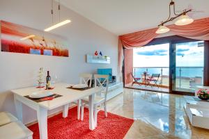 a dining room with a white table and a view of the ocean at Sveti Luka Apartments in Dobra Voda