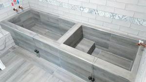 a bathtub in a bathroom with white tile at Royal Holiday Imv in Baihe